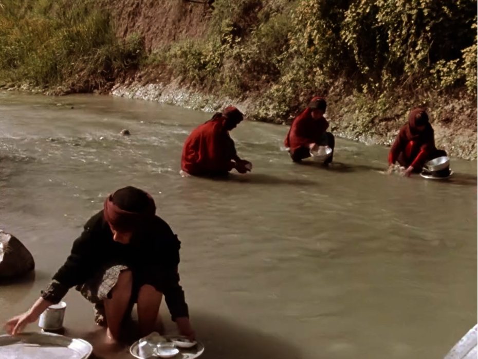 Figure 5: Rūy’bakhayr and the village women washing dishes in the river. Still from The Sealed Soil (Khāk-i sar bih muhr), directed by Marvā Nabīlī, 1977.