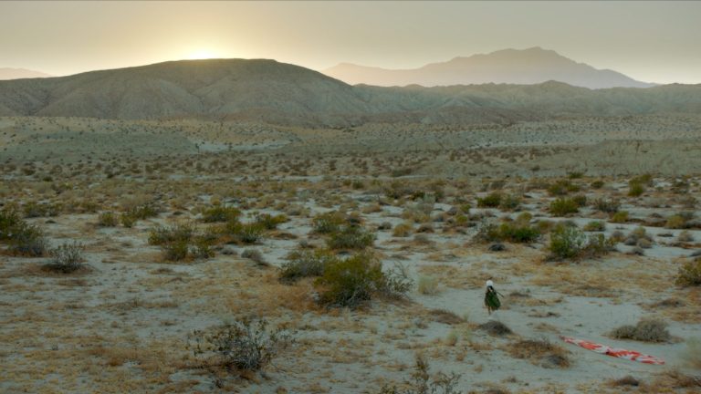 Figure 2: Zaree is entangled in parachuting equipment in a barren field. Still from Born in Evin, directed by Maryam Zaree, 2019.