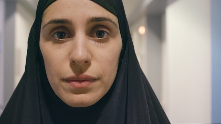 Figure 9: Zaree’s facial expression grows tense in her hyper-conservative outfit. Still from Born in Evin, directed by Maryam Zaree, 2019.