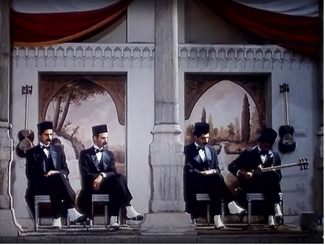 Figure 6: Four musicians performing in front of painted backdrops reminiscent of 19th-century photographic studios, still from the film Love Stricken (Dilshudigān), directed by ‘Alī Hātamī, 1992.