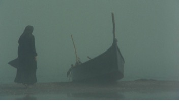 Figure 2: Parvānah Ma‛sūmī standing beside the boat which carried Āyat in a scene from The Stranger and the Fog (Gharībah va Mih), directed by Bahrām Bayzā’ī, 1974.